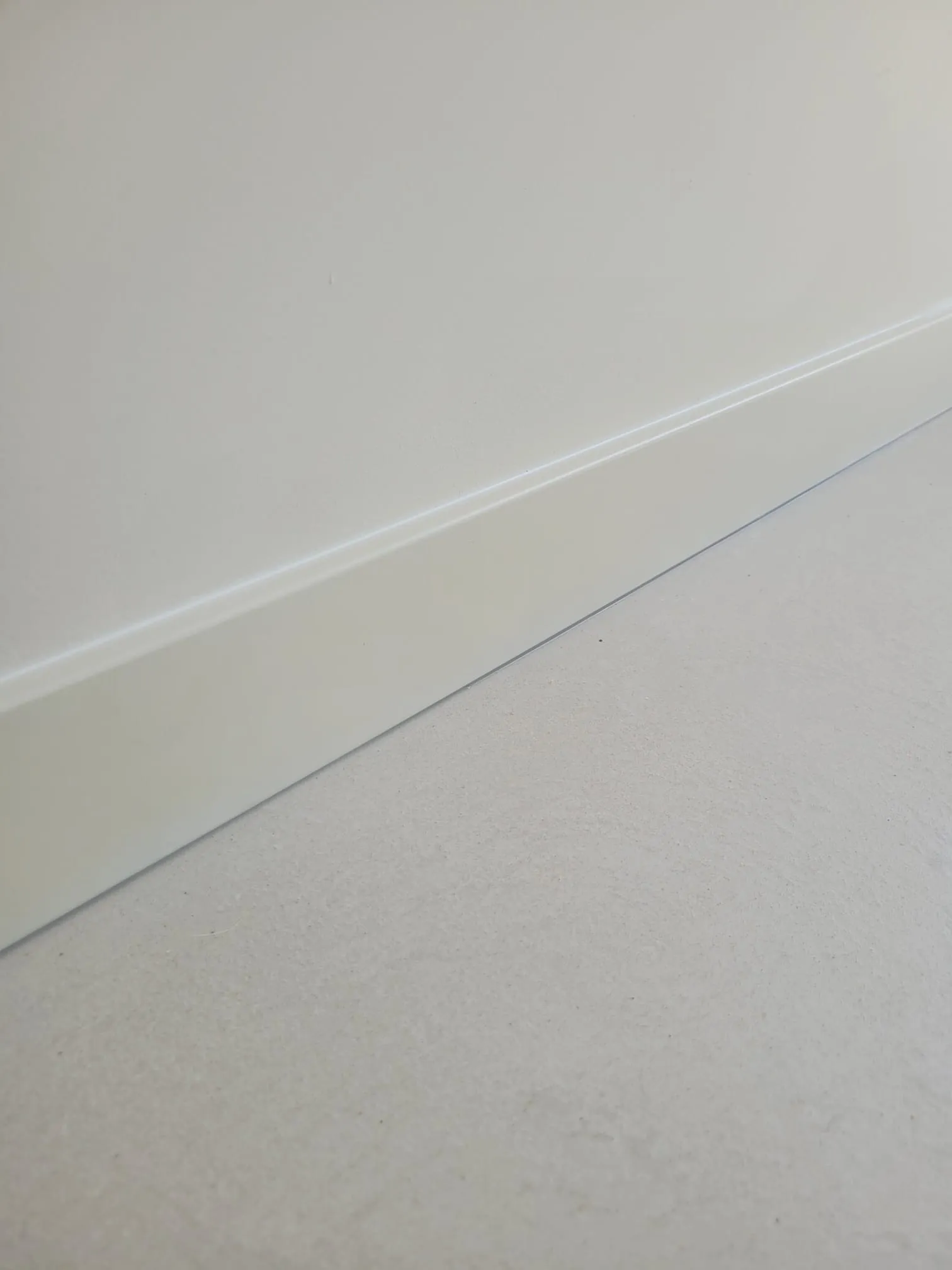 Naadloze plint op gietvloer in moderne wandafwerking